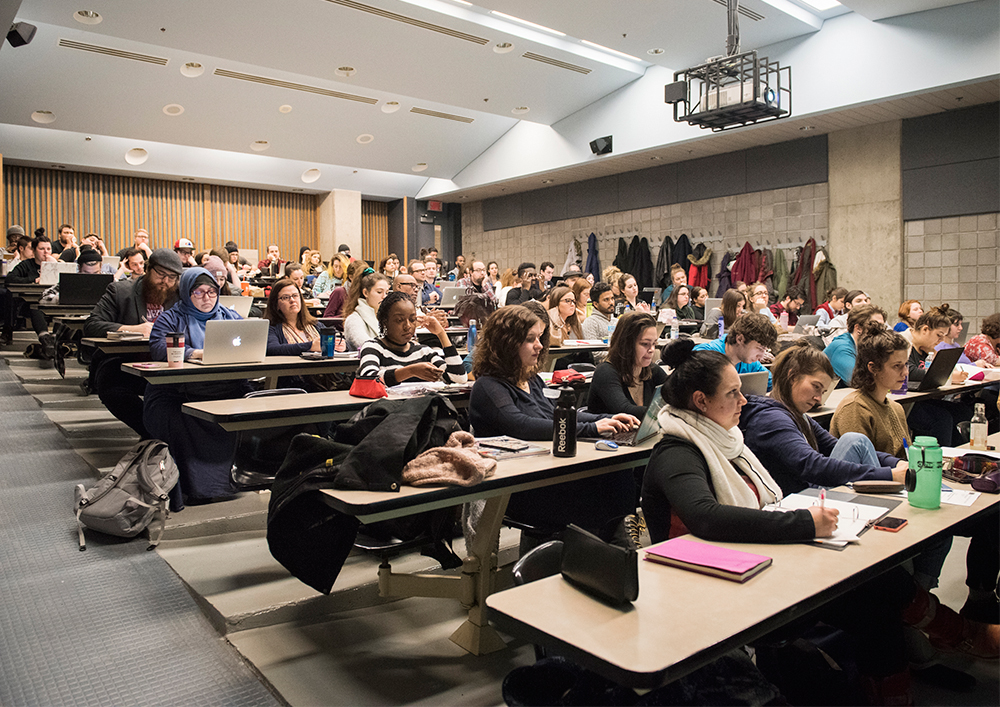 Ensemble d'étudiant suivant un cours dans une salle de classe