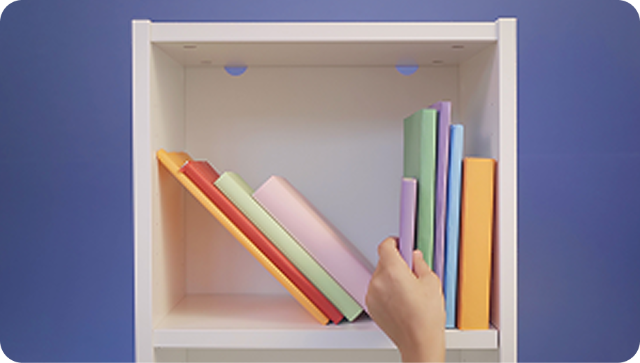 Une main récupère un livre dans une bibliothèque